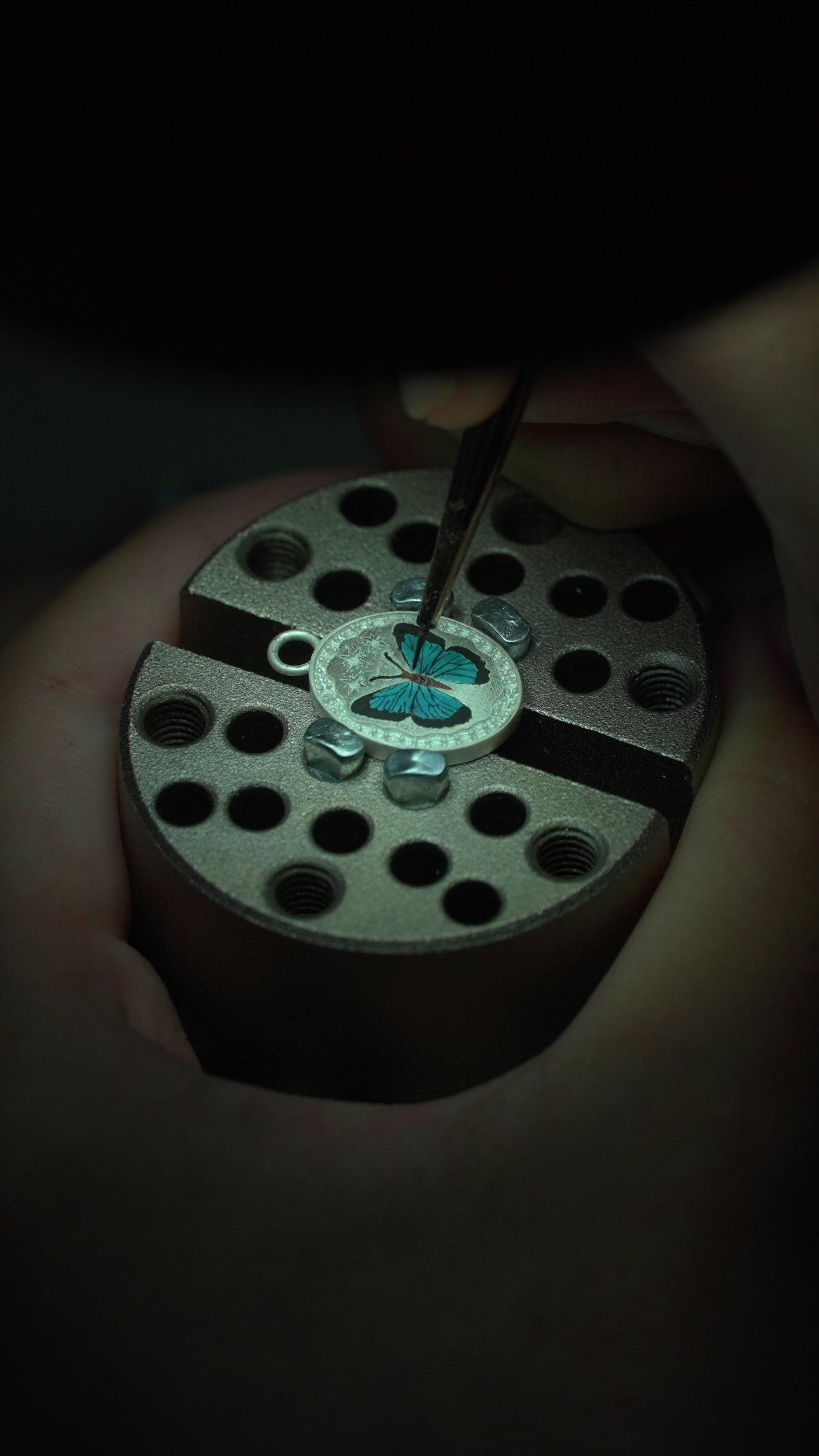 The painter's hands at the microscope, laying color with a fine brush